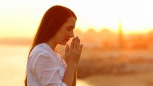 woman being gracious with her hands together in prayer