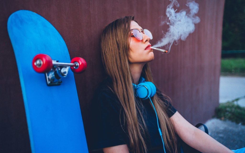 girl smoking cannabis while skateboarding