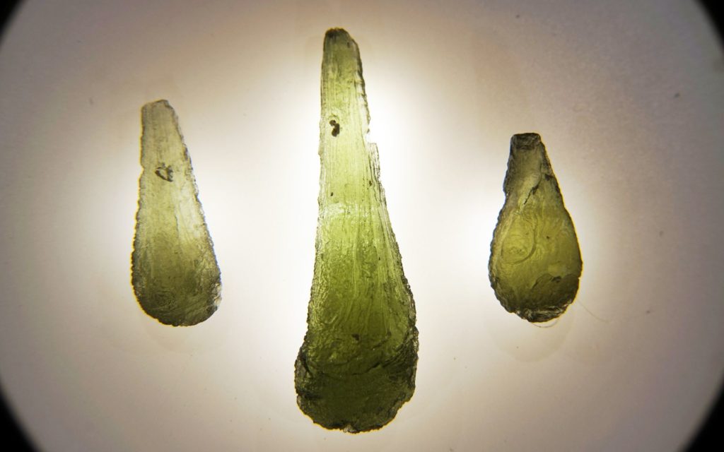 3 different sizes of moldavite crystals next to each other